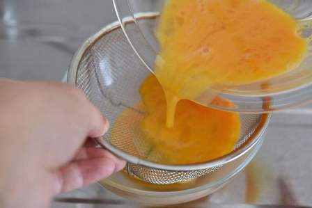 ざるで卵液を濾す
