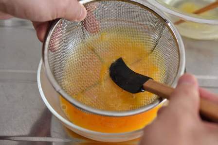 ざるの内側をヘラで濾す