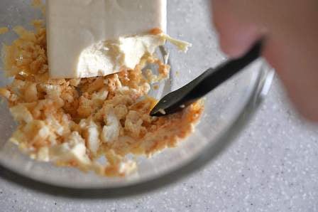 ヘラで調味料と豆腐を混ぜる