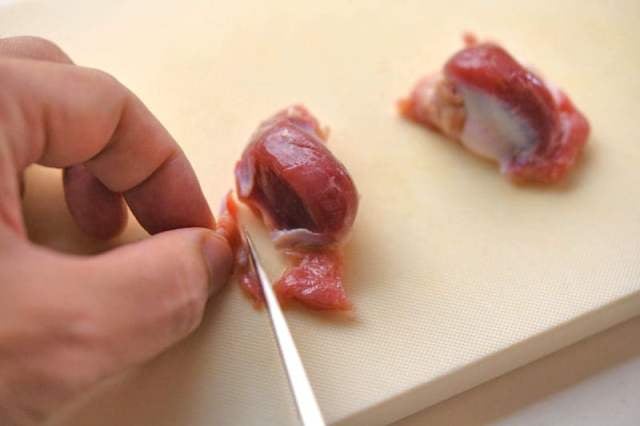 砂肝の硬い皮を包丁でのぞく