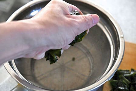 切った生わかめをしぼる