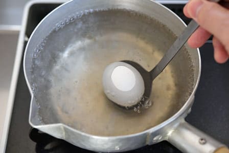 お玉でそっと卵を入れる